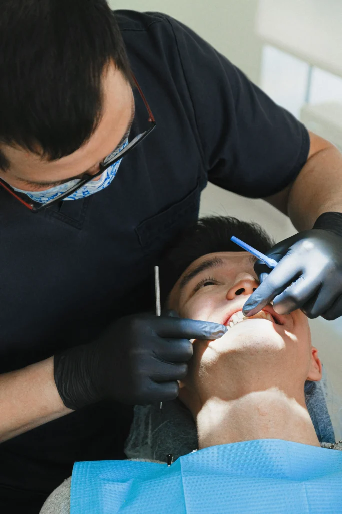 A man tooth is checking by a dentist